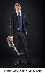 Saxophone Player Man Isolated Against Black Background. Full Body Studio Portrait.