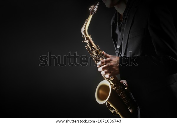 Saxophone player.\
Saxophonist hands playing saxophone. Alto sax player with jazz\
music instrument\
closeup