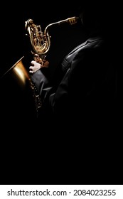 Saxophone Player. Saxophonist With Sax Baritone. Jazzman Playing Jazz Music Instrumen Isolated On Black Background