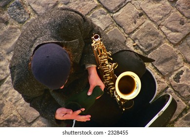 A Saxophone Playing Busker Packs Up At The End Of The Day On The Streets Of Paris.