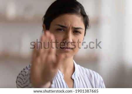 I say enough. Portrait of desperate indian woman showing stop gesture to any manifestations of racial gender discrimination. Strong hindu lady look at camera defend female right for free determination
