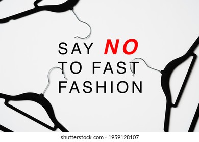 Say No To Fast Fashion Sign Over Heap Of Hangers On White Background.. Fast Fashion Is Bad For The Environment