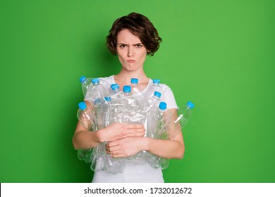 Say No to Plastic concept. Photo of beautiful lady hold many plastic empty bottles against pollution angry face carry trash recycling wear casual t-shirt isolated green color background