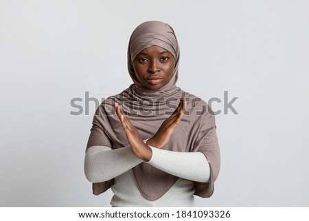 Say No To No Racism. Serious Black Muslim Woman In Hijab Showing Cross Hands Gesture, Demonstrating Denial Sign, Rejecting Something Unwanted, Posing Over Light Studio Background, Copy Space