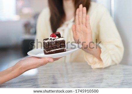 Say no to sweet during diet. Woman refusing to eat cake and push off.