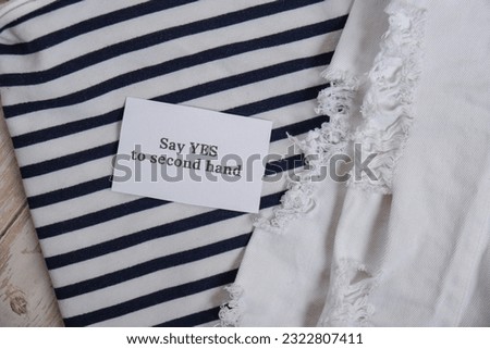 SAY YES TO SECOND HAND text on paper note on clothes assortment Second hand sustainable shopping. Capsule minimal wardrobe. Sustainable fashion overconsumption, conscious buying consumption, slow