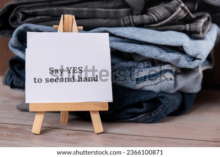 SAY YES TO SECOND HAND text on paper note on Jeans clothes assortment Second hand sustainable shopping. Capsule minimal wardrobe. Sustainable fashion overconsumption, conscious buying consumption