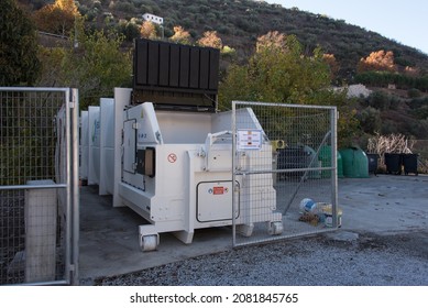 SAYALONGA, SPAIN - November 23, 2021: large hydraulic paper press or compactor at a recycling point (punto limpio) - a sign states in Spanish, English and German that the press is for paper only