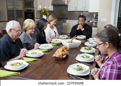 saying grace at meal / a family get together / people fold their hands  - Powered by Shutterstock