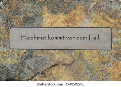 Saying on a rustic background: Arrogance comes before the fall.