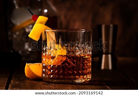Sazerac, classic alcoholic cocktail with cognac, bourbon, absinthe, bitters, sugar and lemon zest. Old wooden background with copy space