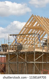 Scaffold platform and timber roof trusses on new building under construction. Home being built on a housing estate as part of urban development. - Shutterstock ID 1158169705
