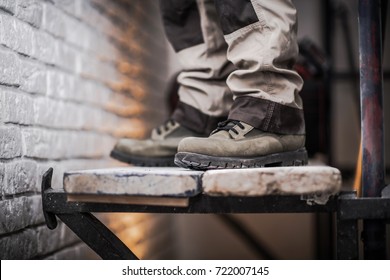 Scaffold Use In Construction Industry Concept Photo. Men Staying On Wood Planks Part Of The Scaffolding. 