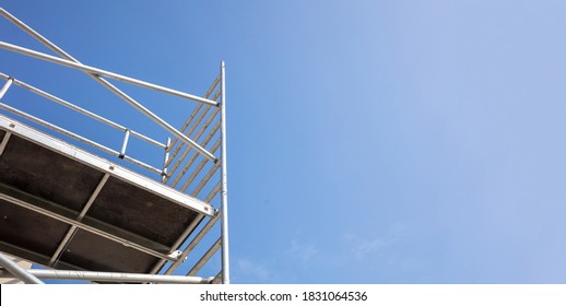 Scaffolding, metal mobile scaffold aginst blue sky background. Under construction, maintenance renovation works concept