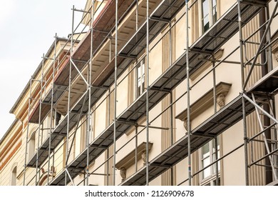 Scaffolding on a generic old tenement house, renovated historical building facade detail, closeup, nobody. Restoration industry, old architecture, real estate renovation simple concept, no people - Shutterstock ID 2126909678