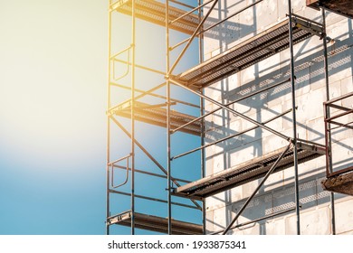 Scaffolding on multi storey building facade during facade renovation. Bright sunny day.