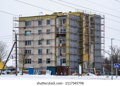 Scaffolding on multi storey building facade during renovation. Exterior passive house wall heat insulation with mineral wool. Insulation facade of multistory residential building. Energy efficiency.