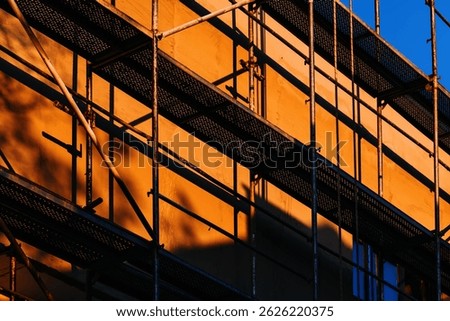 Scaffolding structure on two storey building construction site, industrial background