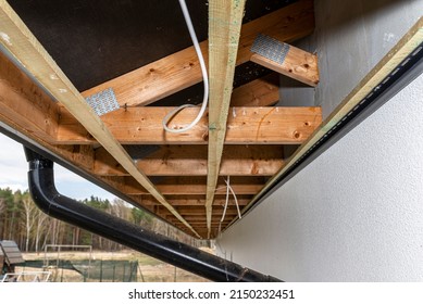 Scaffolding With Three Rows Of Wooden Battens For Attaching The PVC Soffit, Visible Cables For Lighting.