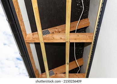 Scaffolding With Three Rows Of Wooden Battens For Attaching The PVC Soffit, Visible Cables For Lighting.