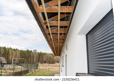 Scaffolding With Three Rows Of Wooden Battens For Attaching The PVC Soffit, Visible Cables For Lighting.