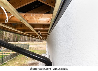 Scaffolding With Three Rows Of Wooden Battens For Attaching The PVC Soffit, Visible Cables For Lighting.