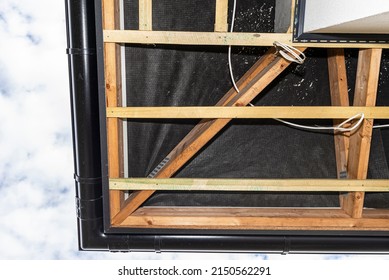 Scaffolding With Three Rows Of Wooden Battens For Attaching The PVC Soffit, Visible Cables For Lighting.