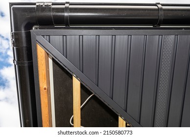 Scaffolding With Three Rows Of Wooden Battens And A Modern Graphite Soffit, Visible H And J Slats.