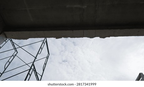 Scaffolding underconstruction with cloudy sky.
