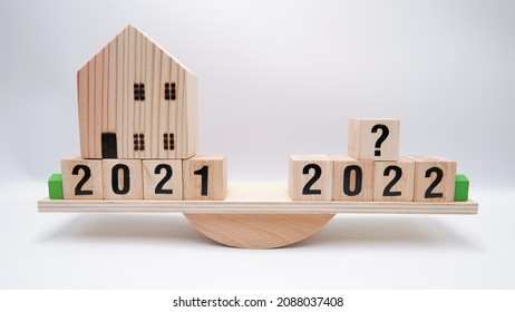 Scale Comparing 2021 And 2022 Housing Market Trends, Question On Real Estate Economics Future Plan And Property Value Analysis. Business Concept Of Forecasting Financial Effect From Coronavirus Crisis