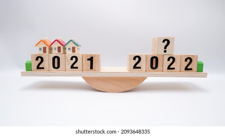 Scale Comparing 2021 And 2022 Housing Market Trends, Question On Real Estate Economics Future Plan And Property Value Analysis. Business Concept Of Forecasting Financial Effect From Coronavirus Crisis