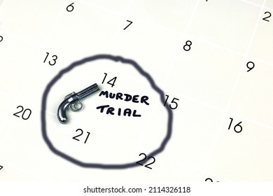 A Scale Model Hand Gun And The Words Murder Trial Written On A Calendar. 