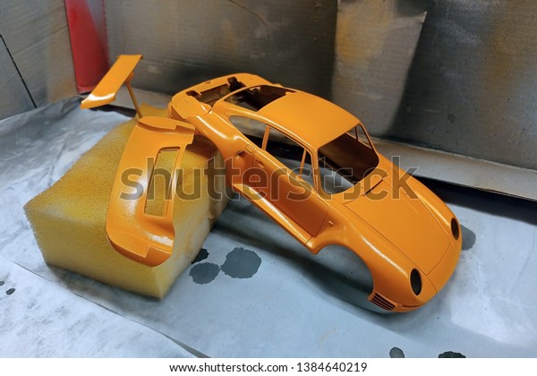 Scale model hobby. Paint the spoiler, trunk\
lid and toy body in a bright orange\
color.