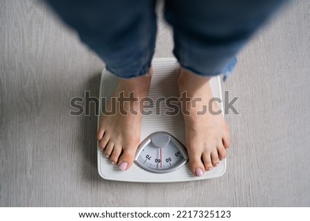 Scale Woman Feet Standing On Weight Scale In Bathroom. Cholesterol Control