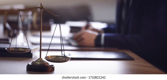 Scales Of Justice And Blurred Lawyer On Background. Banner Design