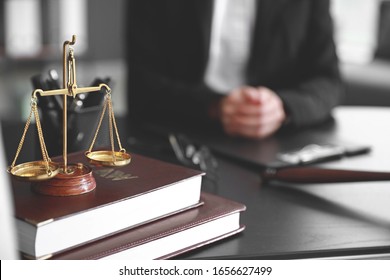 Scales of justice with law books on table of notary public in office