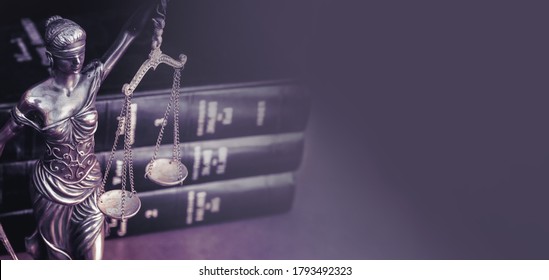 Scales of  justice and law books on desk.