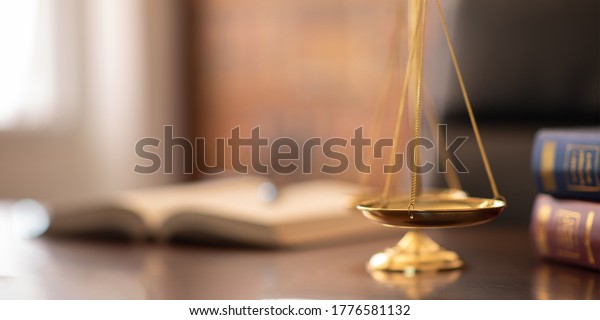 scales\
of justice with law books on desk of lawyer. concept of justice,\
legal, jurisprudence. wide view with copy\
space.