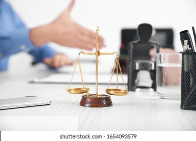 Scales Of Justice With Mobile Phone On Table Of Notary Public In Office