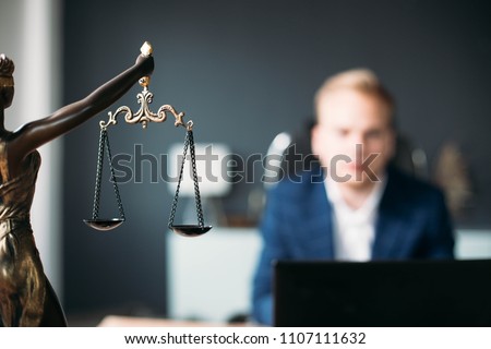 scales of justice. a young man is a lawyer, a judge, a prosecutor. concept of jurisprudence.