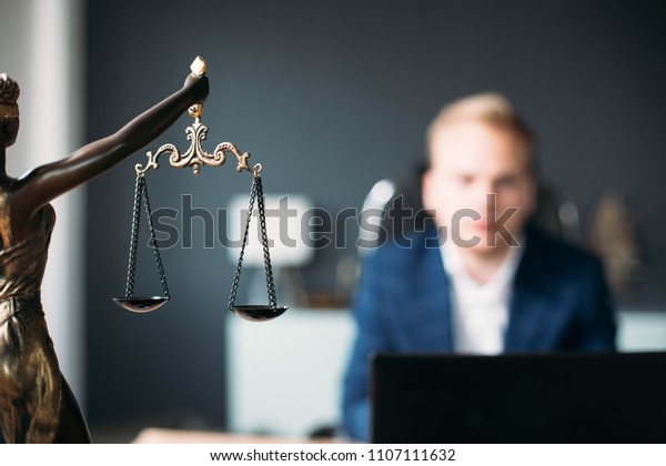 scales of justice. a young man is a\
lawyer, a judge, a prosecutor. concept of\
jurisprudence.