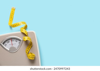 Scales with yellow measuring tape on blue background