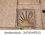 Scallop shell marks the pilgrimage route of the Way of St. James in Spain. Here, the signpost is a slab in the pavement. Seen on the Camino Via de la Plata in Zamora