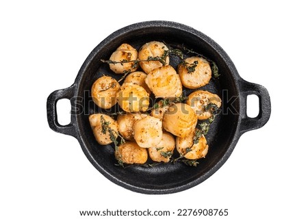 Scallops seared in garlic, thyme and butter served in cast iron skillet. Isolated on white background