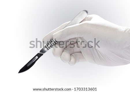 A scalpel in the doctor's hand.
Hand with a surgical scalpel isolated on white background.