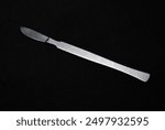 A scalpel on a black background. A medical instrument.