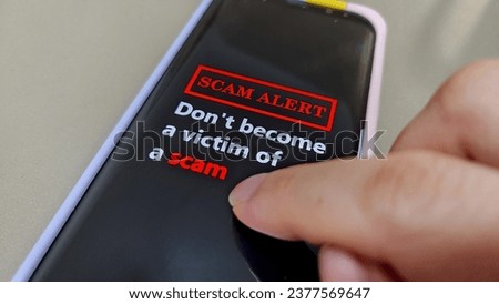 Scam Alert. A mobile phone showing the message Don't Become A Victim Of A Scam