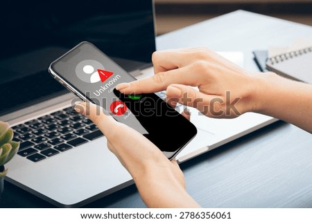 Scam call SMS message displayed on a smartphone with unknown caller ID at a work desk