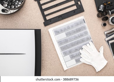 Scan And Archive Photos. Contacts, Cotton Gloves And Roll Of Films On The Wooden Desk 