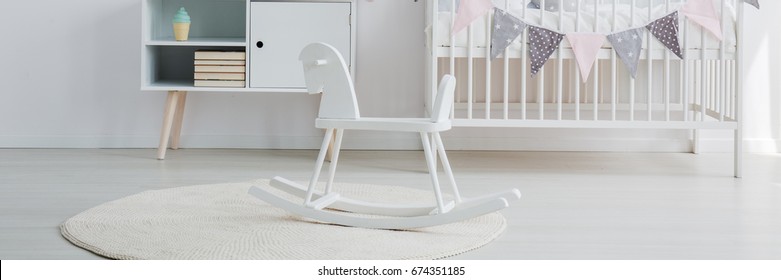 Scandi Baby Nursery With Rocking Horse And White Crib